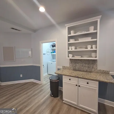 a kitchen with a sink cabinets and wooden floor