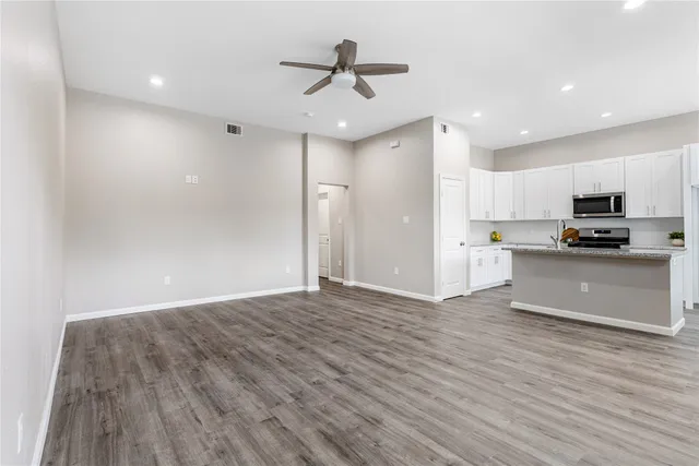 a view of kitchen with granite countertop cabinets and refrigerator