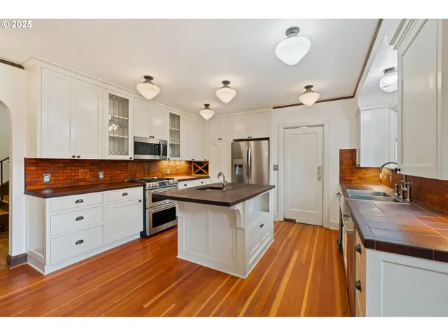 a kitchen with granite countertop a sink stove and refrigerator
