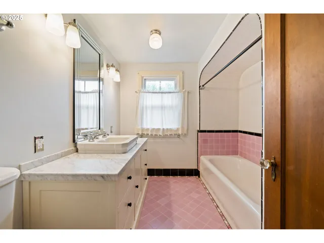 a bathroom with a tub sink and mirror