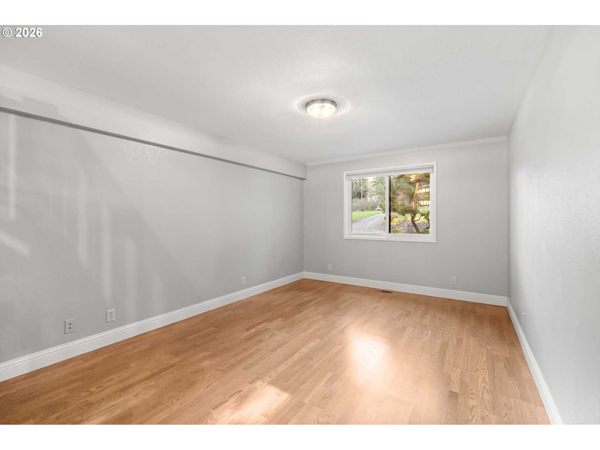 91448 Steinmetz Road Junction City, OR 97448 - Photo 31 of 48 a view of an empty room with a window and wooden floor