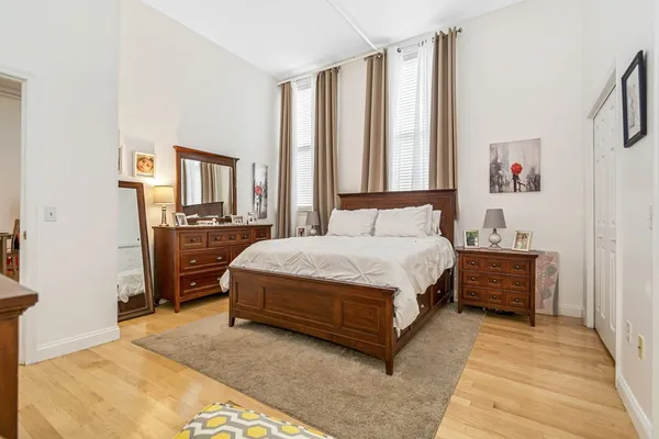 a spacious bedroom with a bed and a cabinets