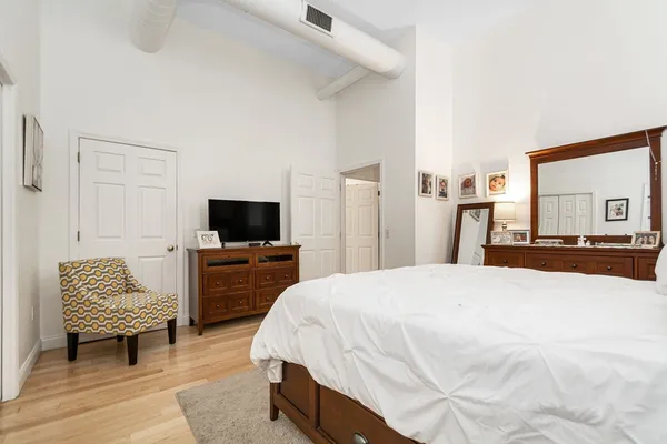 a spacious bedroom with a bed and a television