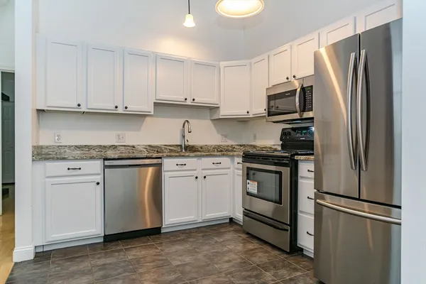 a kitchen with stainless steel appliances granite countertop a refrigerator sink and stove