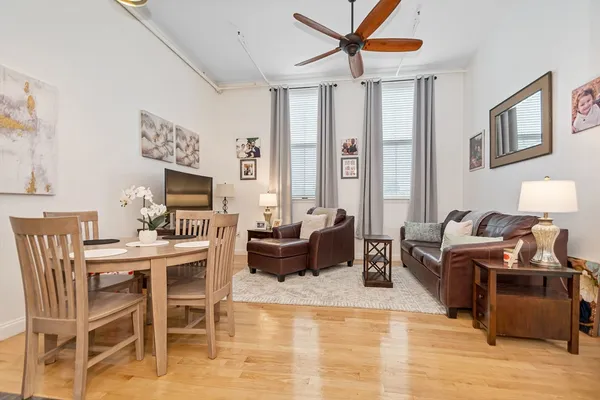 a living room with furniture a ceiling fan and a window