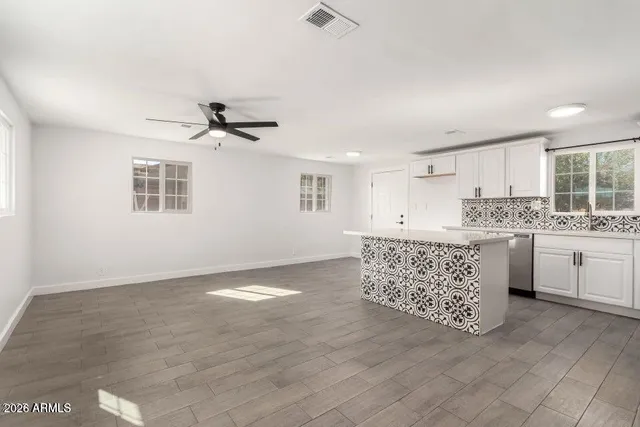 a kitchen with stainless steel appliances kitchen island granite countertop a stove a sink and a refrigerator
