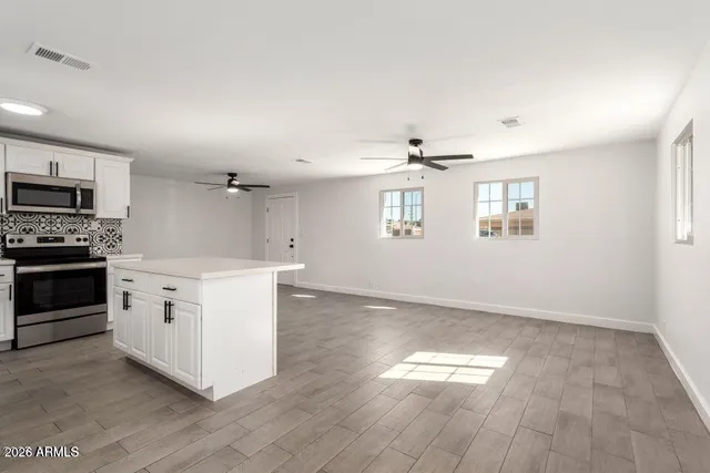 a kitchen with a white cabinets and wooden floor