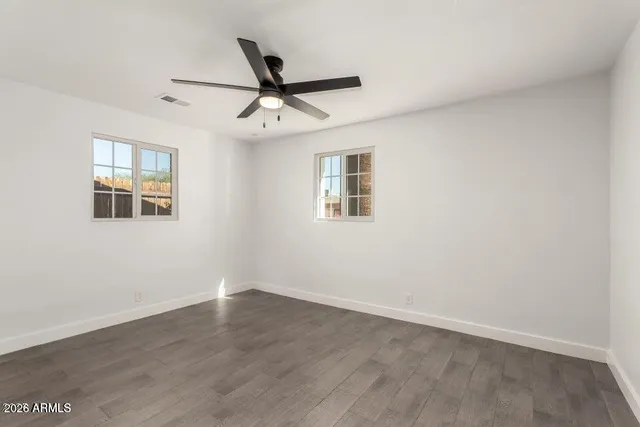 a view of a big room with wooden floor closet and windows