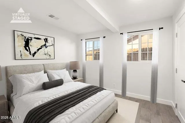 a bedroom with bed and wall painting with wooden floor