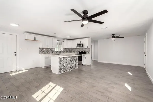 a kitchen with kitchen island white cabinets and refrigerator