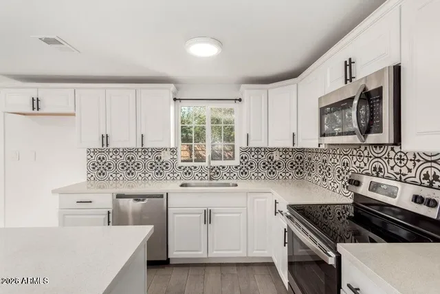 a kitchen with granite countertop a sink stove and cabinets