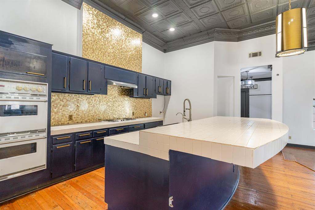 2602 Kings Road, Unit A Dallas, TX 75219 - Photo 11 of 12 Kitchen featuring white appliances, blue cabinetry, an ornate ceiling, light wood-type flooring, and decorative backsplash