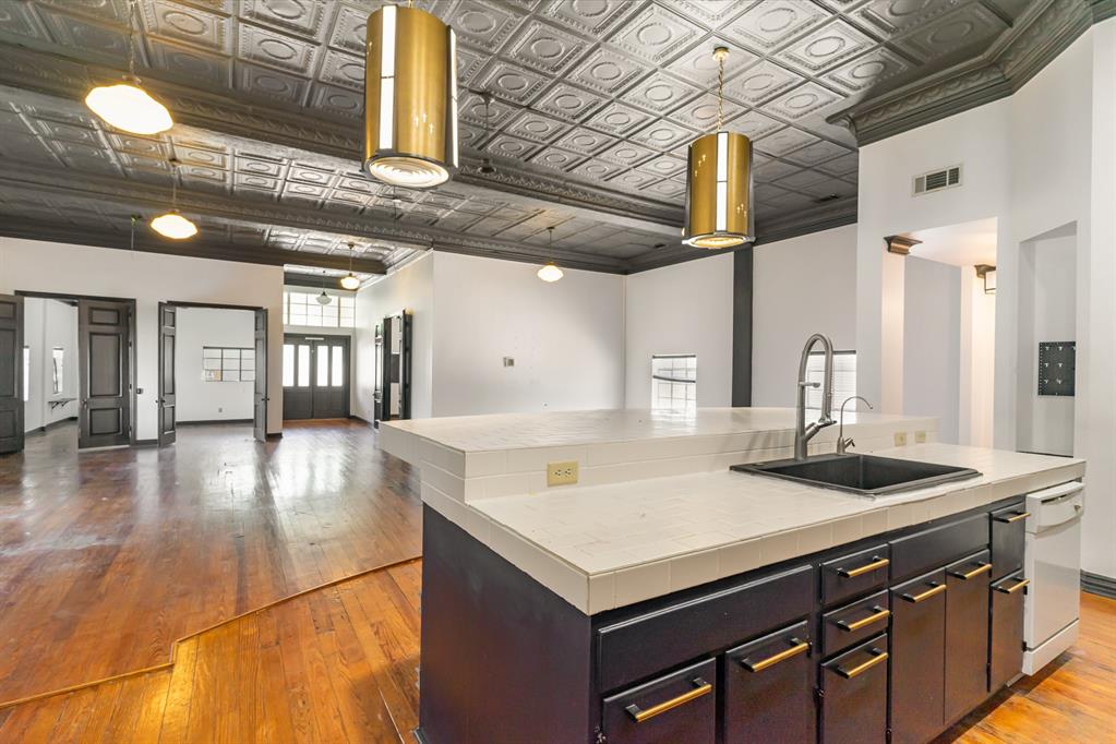 2602 Kings Road, Unit A Dallas, TX 75219 - Photo 4 of 12 Kitchen with a sink, an ornate ceiling, tile counters, wood-type flooring, and a center island with sink