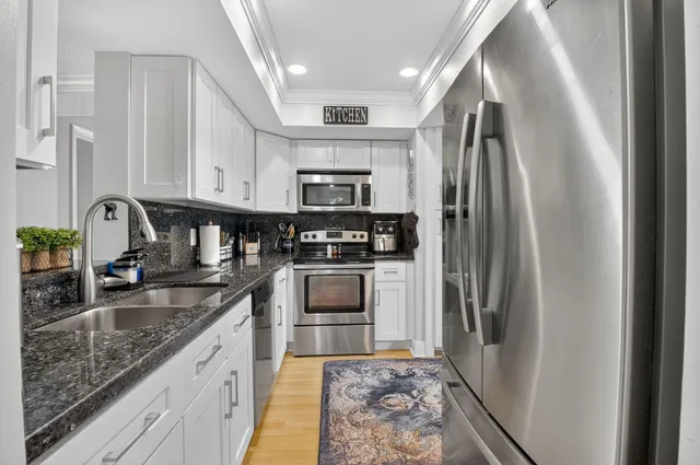 a kitchen with stainless steel appliances granite countertop a sink stove and refrigerator