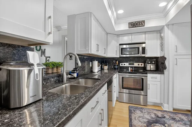 a kitchen with stainless steel appliances granite countertop a refrigerator and a sink