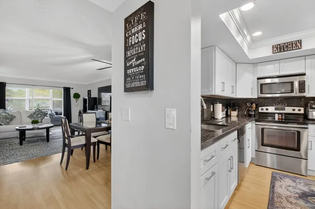 a kitchen with granite countertop a stove a sink and a refrigerator