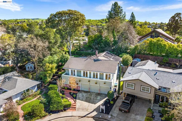 a view of a kitchen with kitchen island stainless steel appliances a stove a sink a dining table and chairs