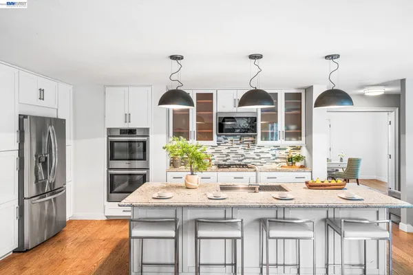 a kitchen with a sink cabinets appliances and wooden floor