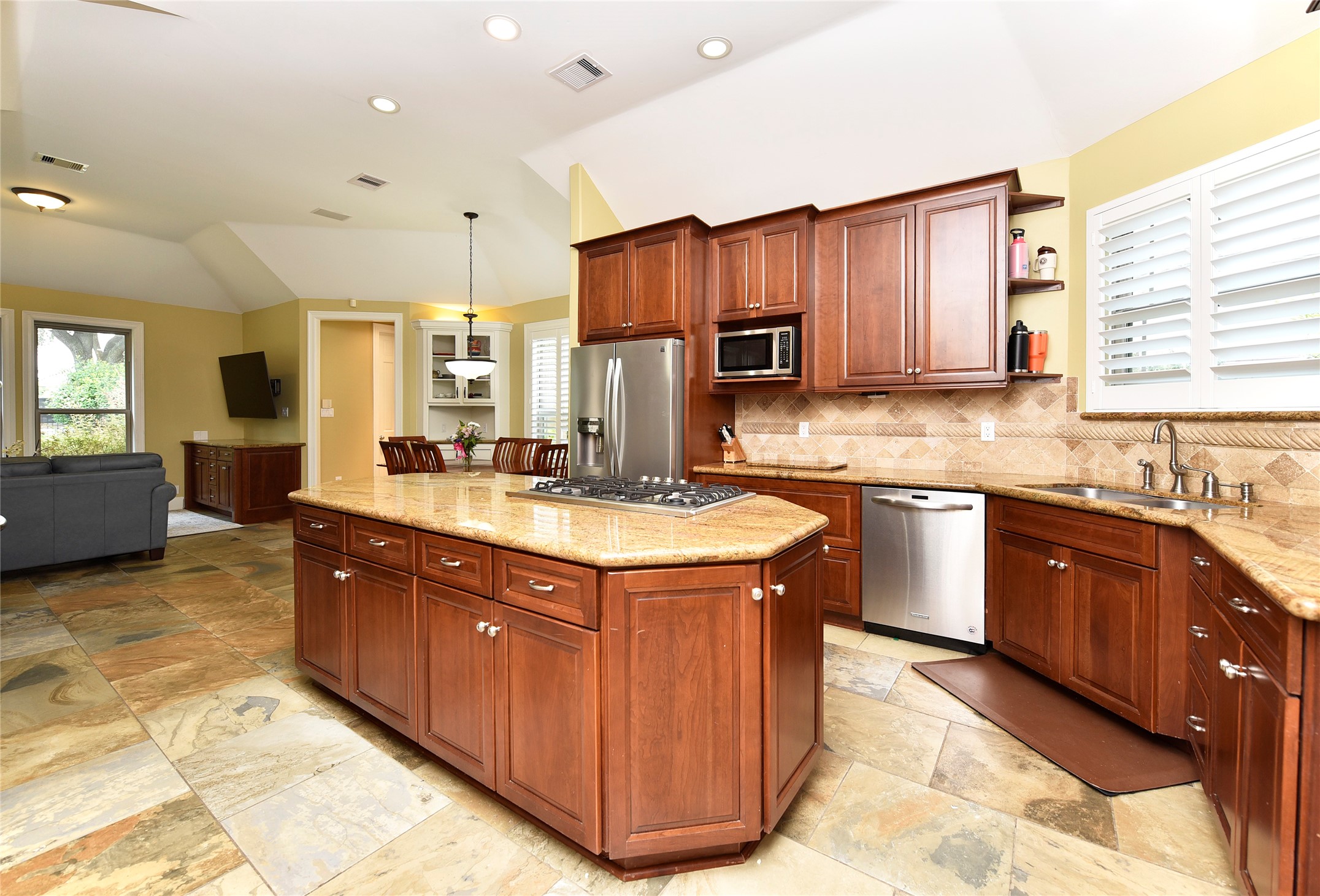 3315 Meadowside Drive Sugar Land, TX 77478 - Photo 12 of 48 a kitchen with kitchen island granite countertop a sink stove and cabinets