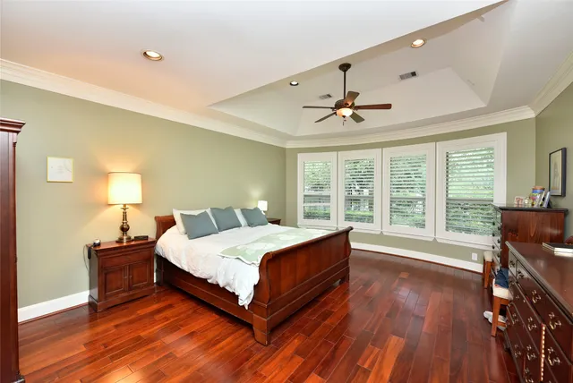 a spacious bedroom with a bed and wooden floor