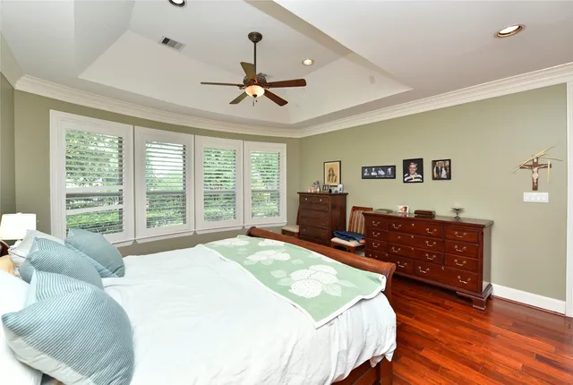 a spacious bedroom with a bed and wooden floor