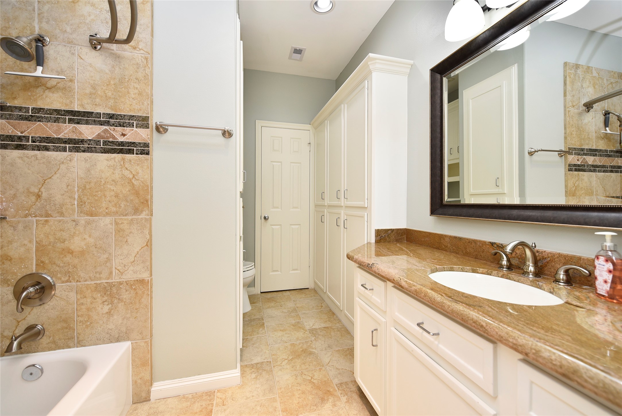 3315 Meadowside Drive Sugar Land, TX 77478 - Photo 31 of 48 a bathroom with a granite countertop sink a mirror and a bathtub