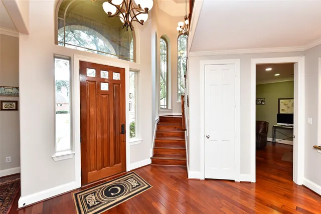 a view of a hallway with wooden floor and staircase