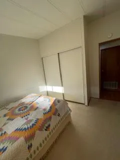 a bed sitting in a bedroom next to a cabinet