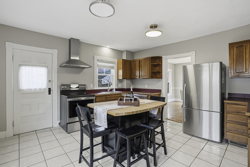 2 Maple Avenue Natick, MA 01760 - Photo 16 of 41 a kitchen with stainless steel appliances granite countertop a sink a stove a refrigerator and a refrigerator with wooden cabinets