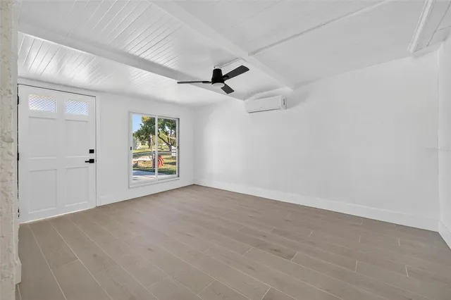 an empty room with windows and ceiling fan