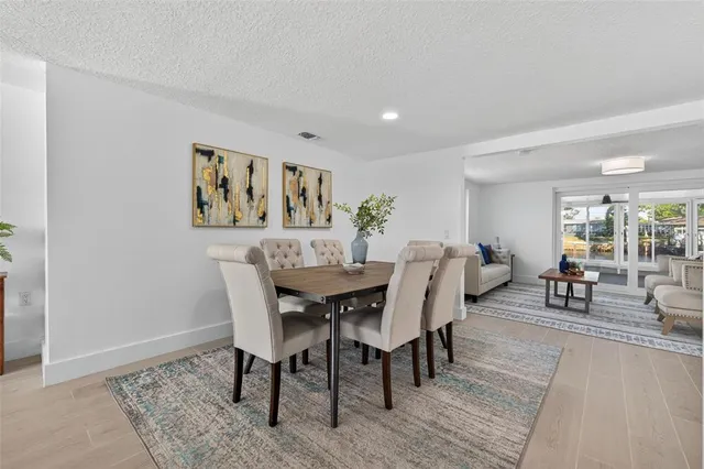 a view of a a dining room with furniture window and wooden floor