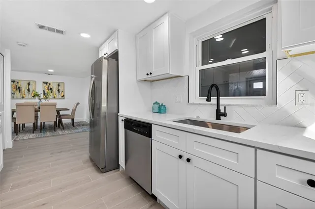 a kitchen with cabinets and chairs