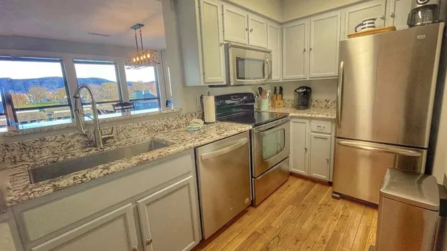 a kitchen with stainless steel appliances a refrigerator sink and cabinets