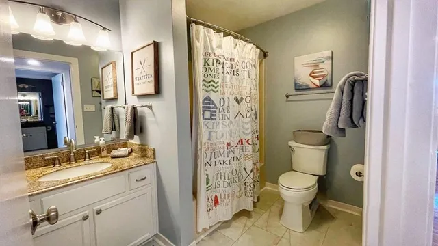 a bathroom with a granite countertop sink toilet and shower