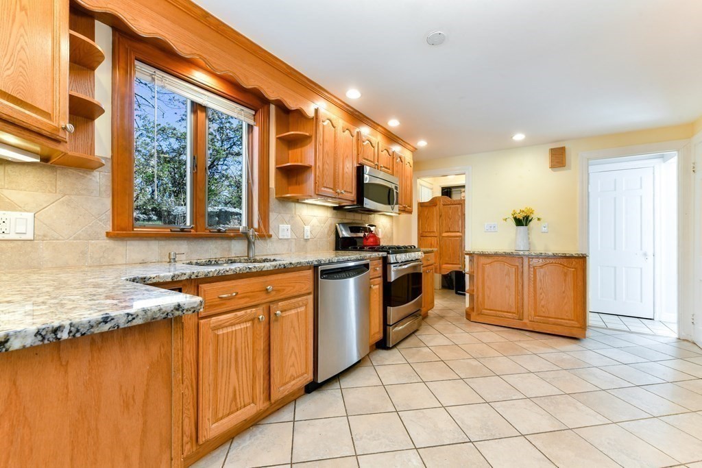 47 White Pine Road Newton, MA 02464 - Photo 5 of 24 a kitchen with stainless steel appliances granite countertop a stove a sink and a microwave