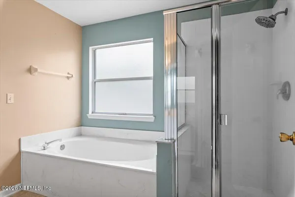 a white bath tub sitting next to a shower