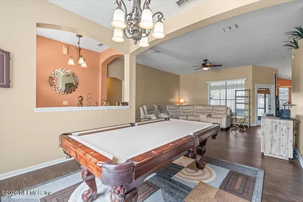 a dining room with wooden floor and chandelier