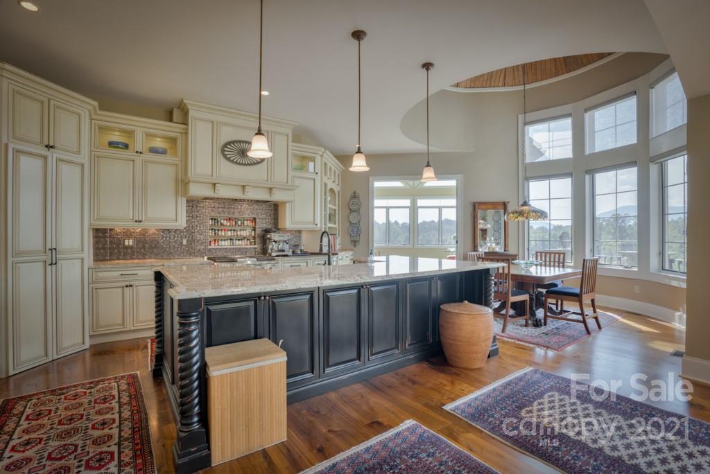 874-a R A R Thompson Road, Unit 24 Mill Spring, NC 28756 - Photo 15 of 47 a open kitchen with stainless steel appliances granite countertop a stove a sink a dining table and chairs with wooden floor