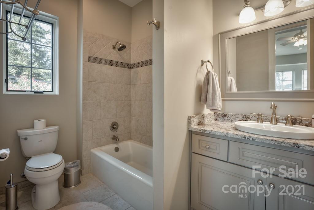874-a R A R Thompson Road, Unit 24 Mill Spring, NC 28756 - Photo 26 of 47 a bathroom with a granite countertop toilet a sink and a bathtub