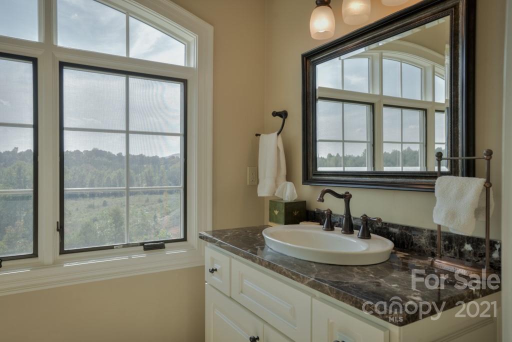 874-a R A R Thompson Road, Unit 24 Mill Spring, NC 28756 - Photo 33 of 47 a bathroom with a granite countertop sink and a mirror