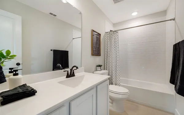 a bathroom with a sink a toilet a mirror and shower
