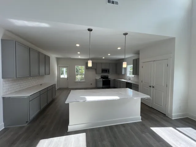 a large white kitchen with a large island oven