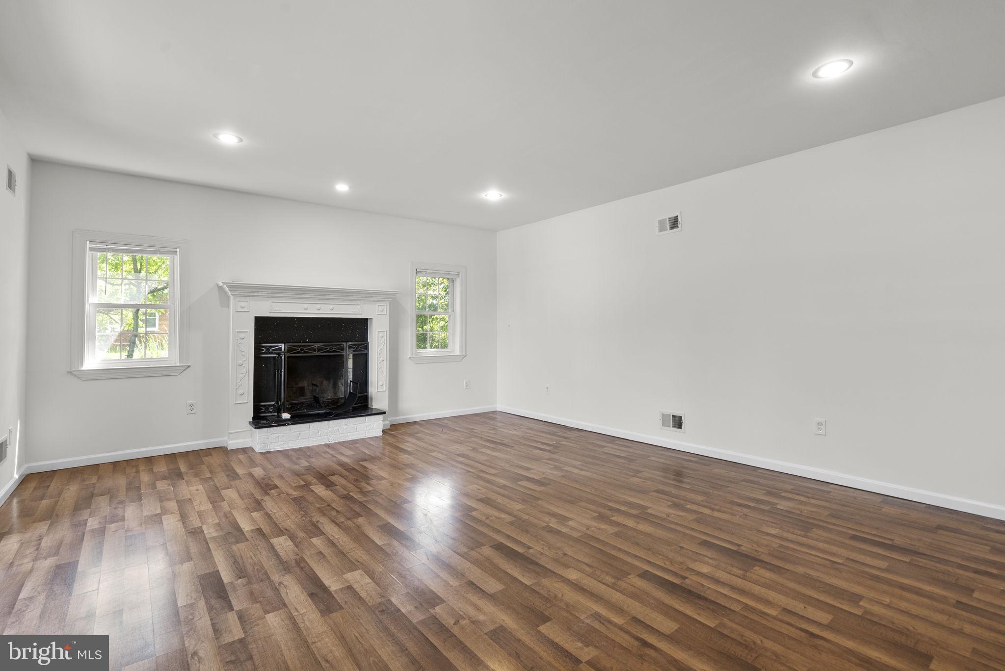 24000 Clarksburg Road Clarksburg, MD 20871 - Photo 5 of 60 an empty room with wooden floor a fireplace and a window