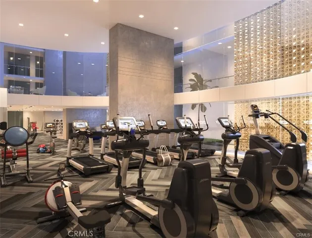 a room with gym equipment and wooden floor