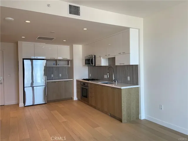 a kitchen with stainless steel appliances a refrigerator sink and microwave