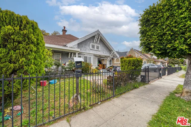 a front view of a house with a garden and plants