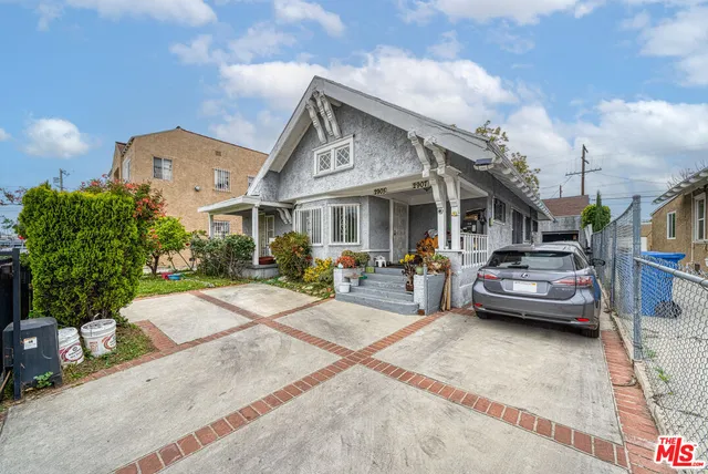 a view of a white house and a yard in front of it