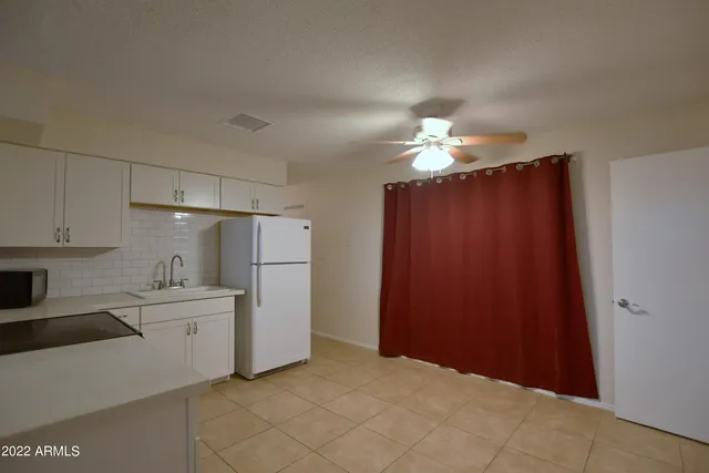 a kitchen with stainless steel appliances a refrigerator and a chandelier