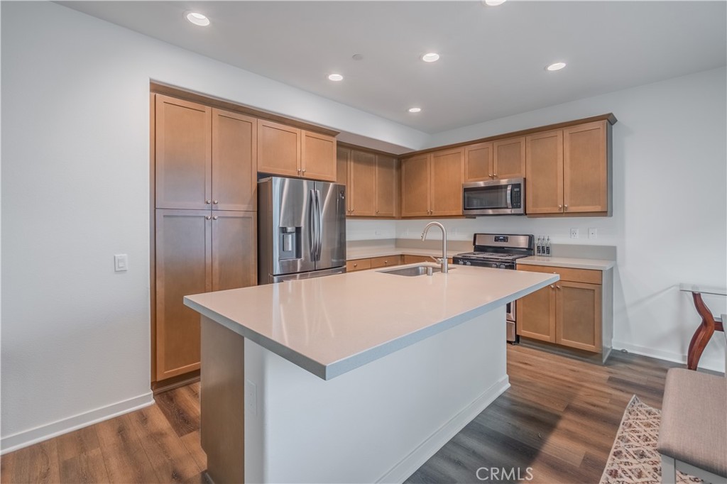 9513 Retreat Place Rancho Cucamonga, CA 91730 - Photo 12 of 49 a kitchen with kitchen island a sink a refrigerator and a stove
