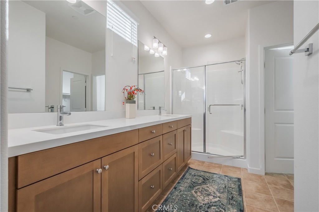 9513 Retreat Place Rancho Cucamonga, CA 91730 - Photo 21 of 49 a bathroom with a double vanity sink a mirror and a shower